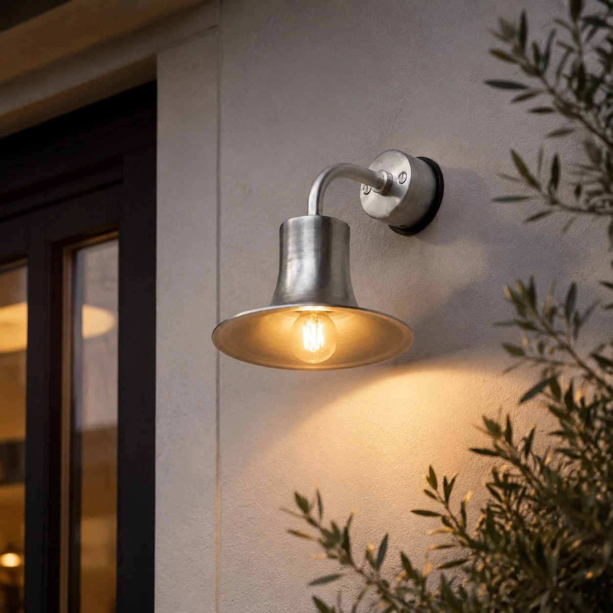 Silver wall sconce installed over an entry sign