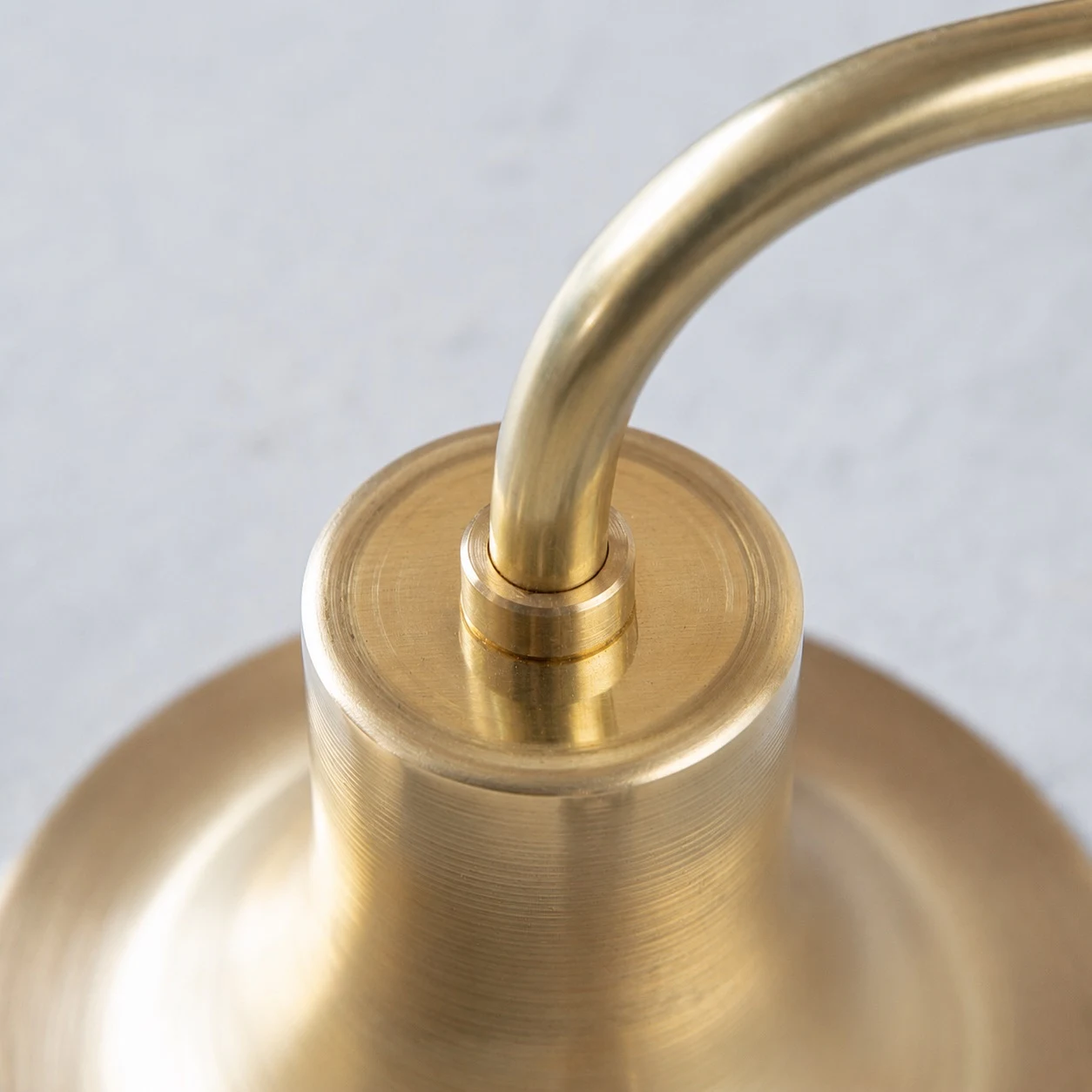 Close-up of curved wall sconce arm and shade connection