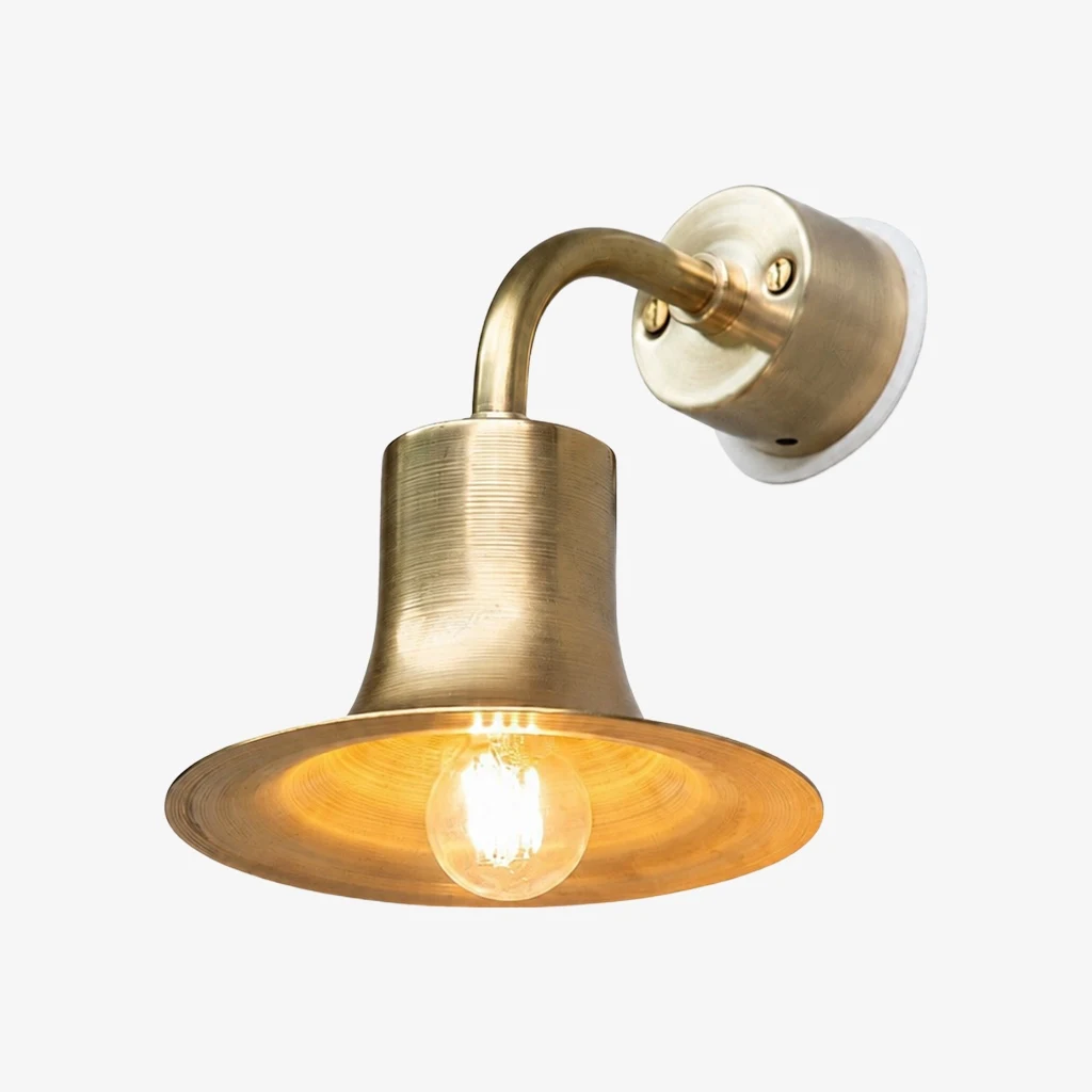 Matte gold brass wall sconce with warm bulb glow