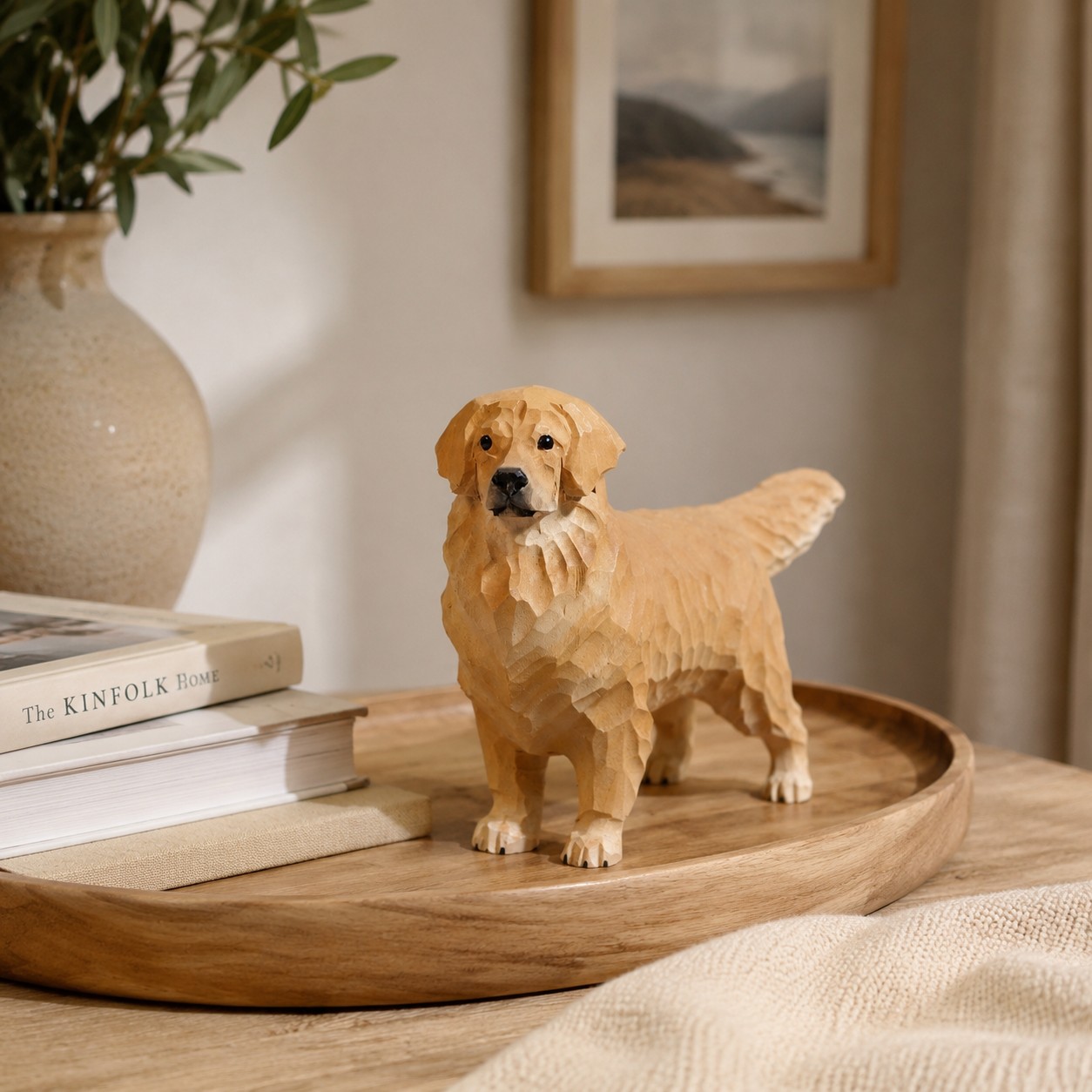 Golden retriever ornament on tray with books and vase
