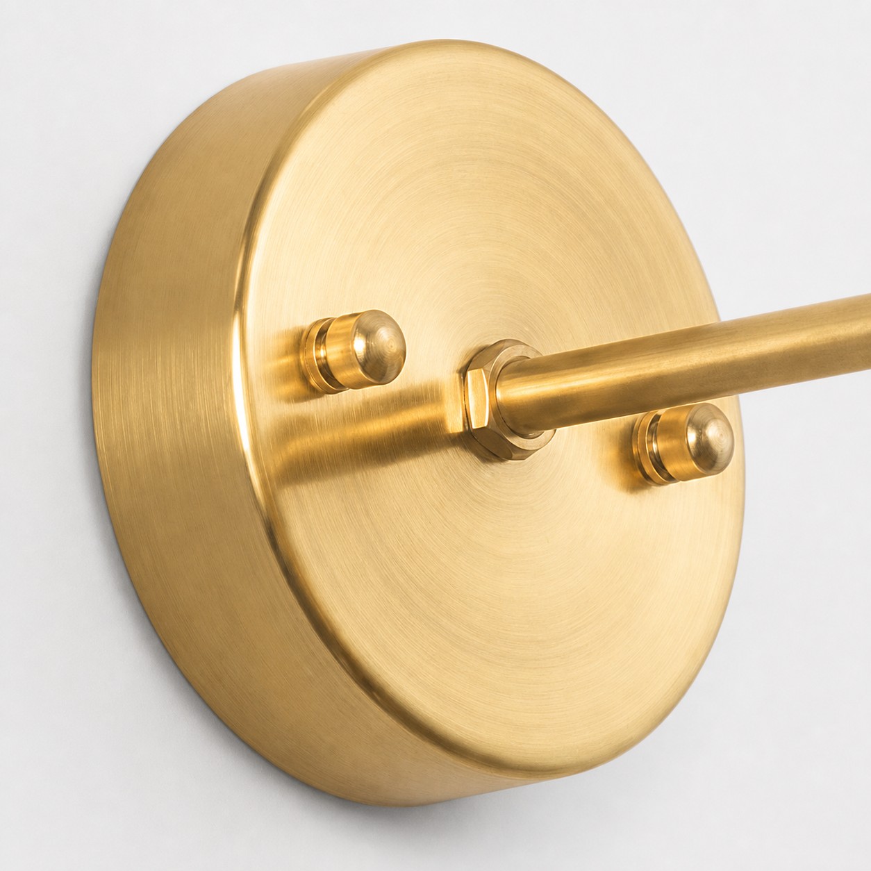Brushed brass circular wall plate and arm detail
