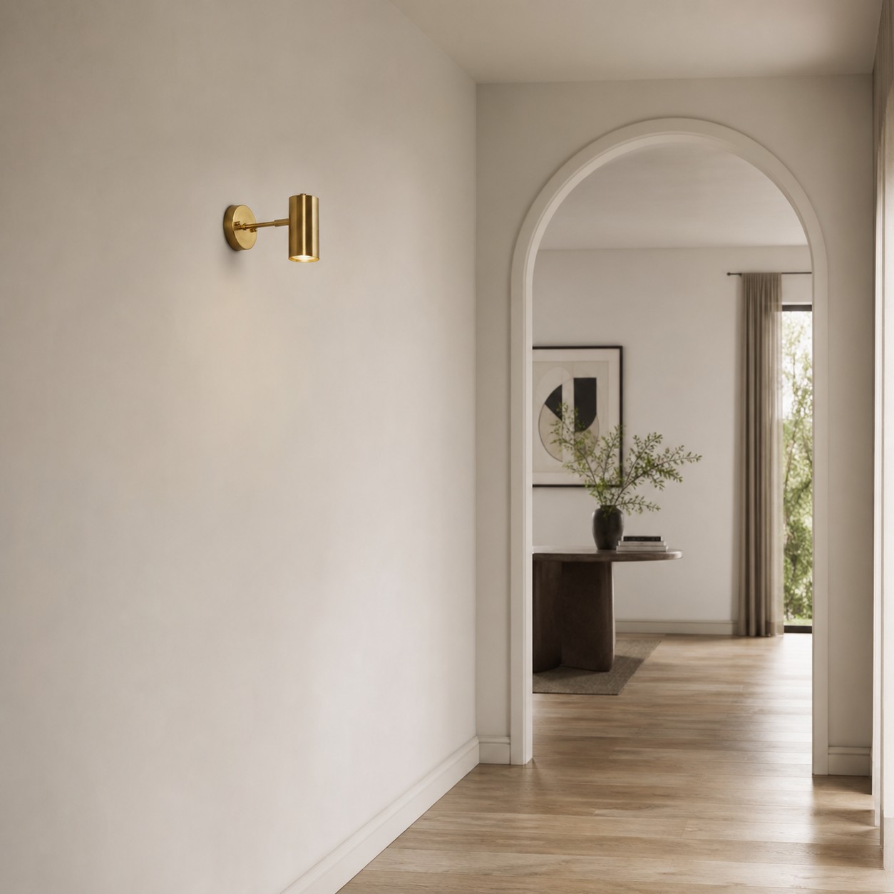 Brass cylinder wall sconce in a bright hallway